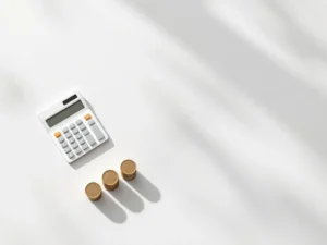 Rekenmachine, euromuntenstapels en huissilhouet in bovenaanzicht voor hypotheek- en financiële berekeningen