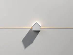 Wit architectuurmodel van huis met gouden lijn op grijze ondergrond, symboliseert hypotheekduur en financiële planning