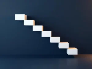 3D-visualisatie van afnemende leningschuld met witte blokken in dalende trap op blauw-gouden achtergrond